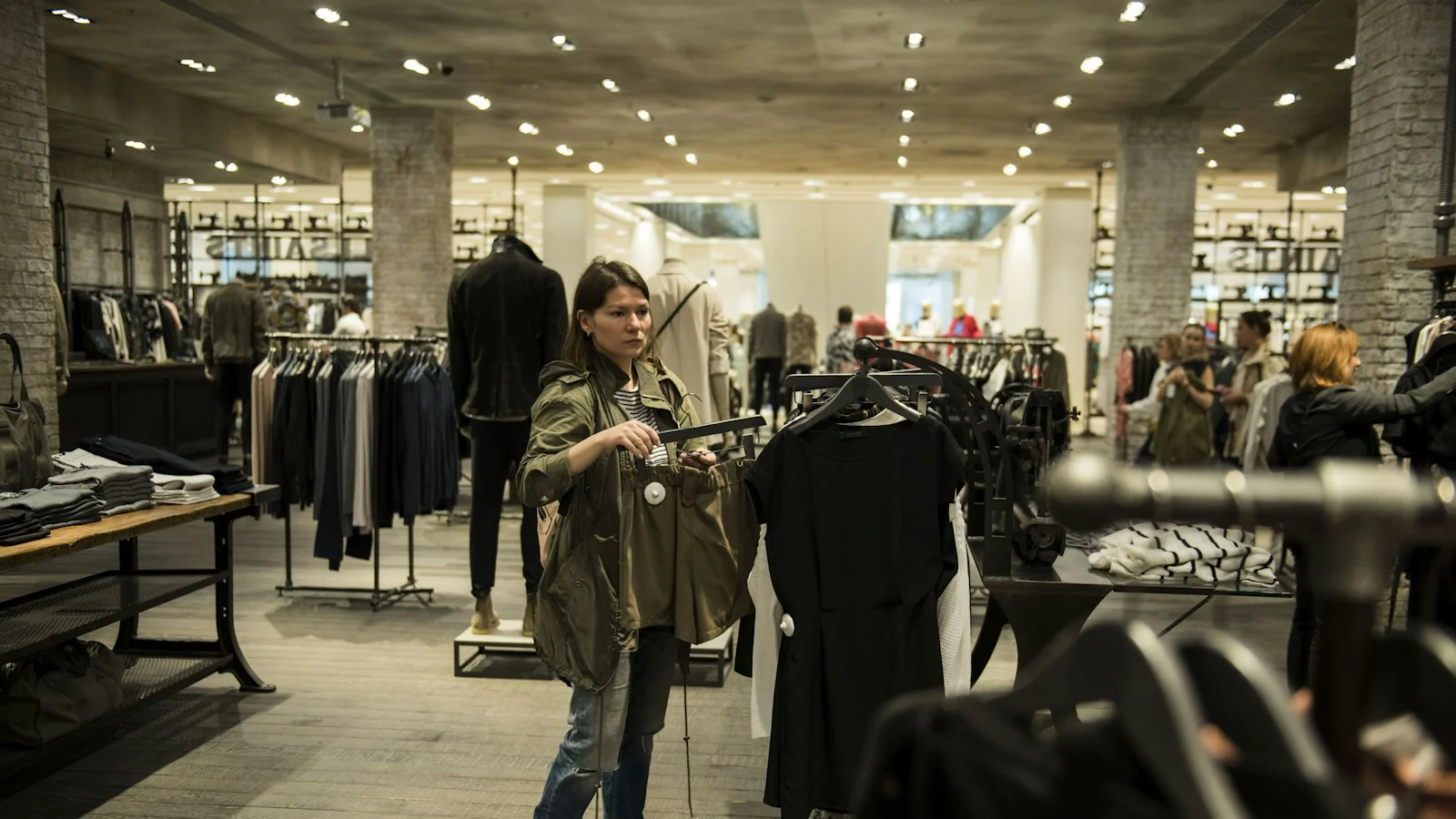 Cliente escolhendo roupas em uma loja movimentada