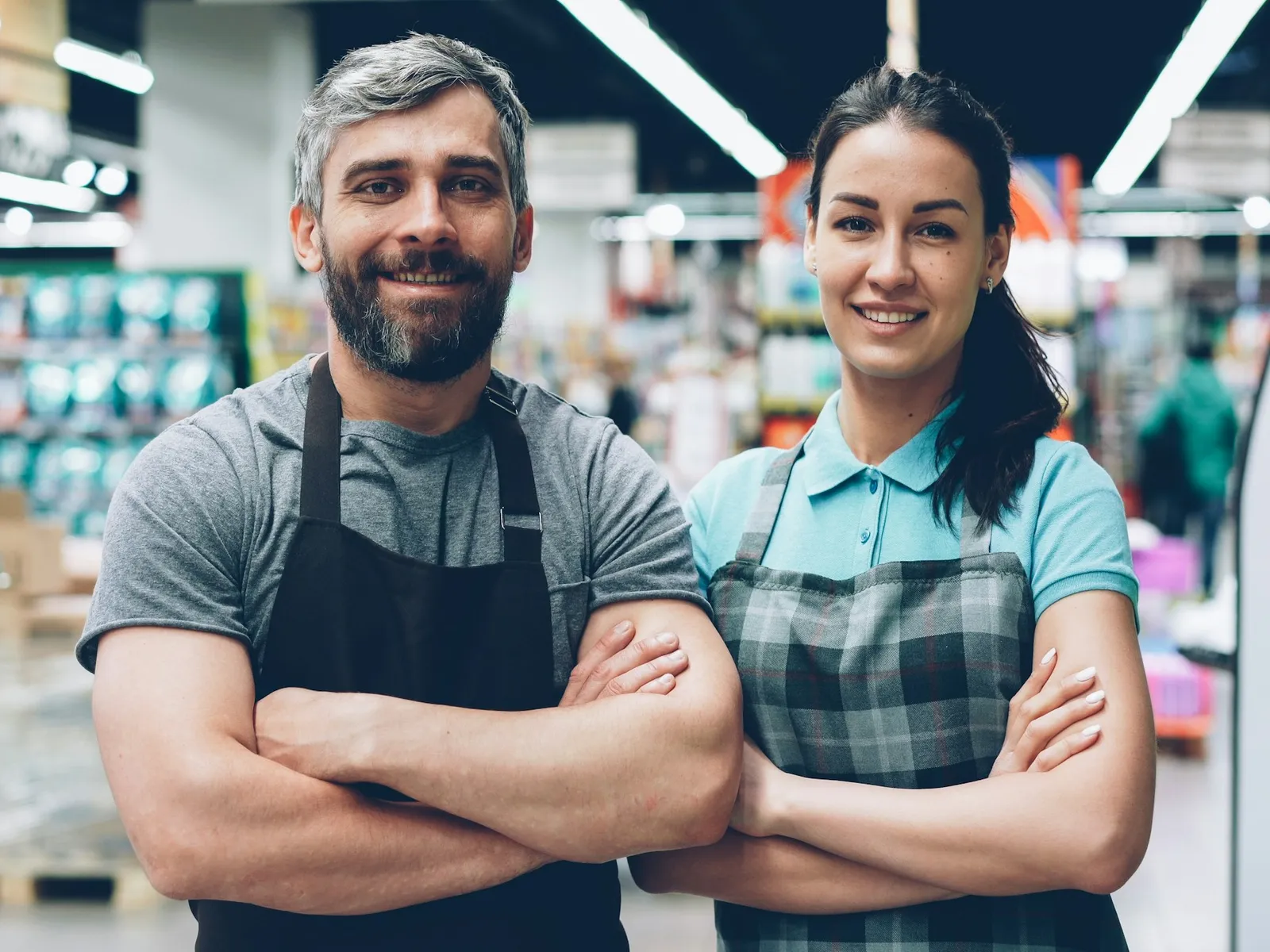 Dupla de funcionários sorrindo dentro de um mercado